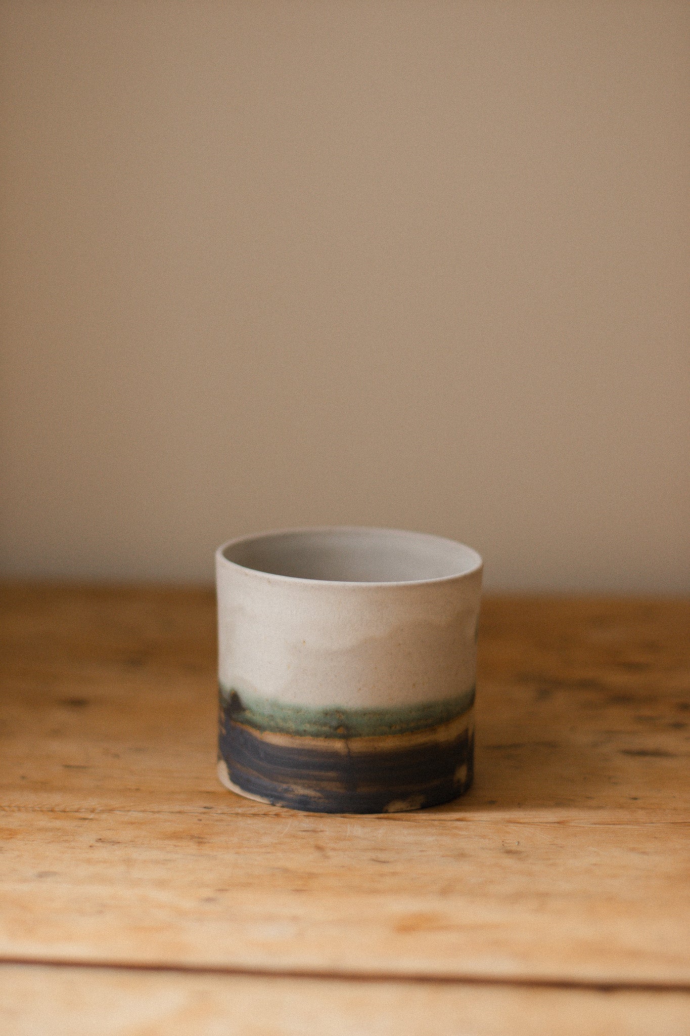 Handmade ceramic plant pot with copper oxide brushed base and matte white glaze, ideal for houseplants, succulents, or decorative home styling.