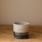 Handmade ceramic plant pot with copper oxide brushed base and matte white glaze, ideal for houseplants, succulents, or decorative home styling.