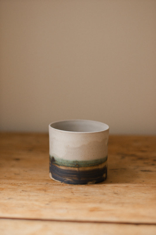 Handmade ceramic plant pot with copper oxide brushed base and matte white glaze, ideal for houseplants, succulents, or decorative home styling.