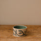 Small ceramic piece with a hand-carved vine pattern filled with matte blue glaze.